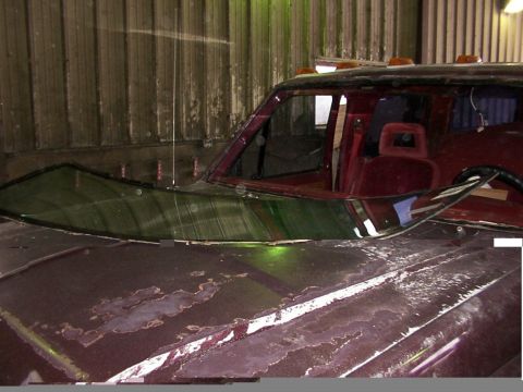 1988 Ford C-350 (Centurion Conversions) - The hood of a truck shows significant paint damage, and the windshield is cracked.