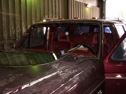 1988 Ford C-350 (Centurion Conversions) - Interior view of a maroon truck with a cracked windshield and worn hood paint.