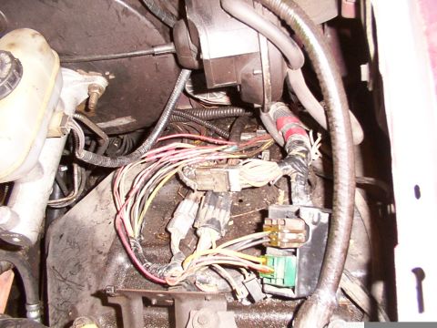 1988 Ford C-350 (Centurion Conversions) - Close-up of a vehicle's engine compartment wiring, showing various connectors and bundles of wires.