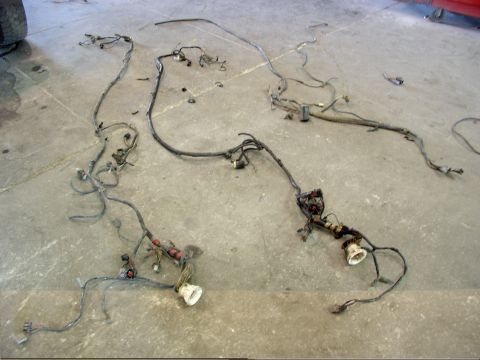 1988 Ford C-350 (Centurion Conversions) - Engine wiring harness components spread across a concrete surface.