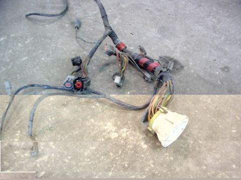1988 Ford C-350 (Centurion Conversions) - A complex vehicle wiring harness lies on a concrete surface, showing various connectors and bundles of wires.