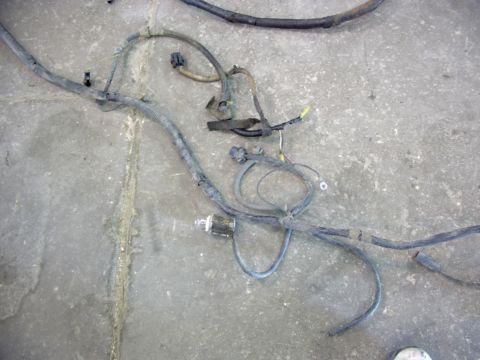 1988 Ford C-350 (Centurion Conversions) - A complex automotive wiring harness, likely from an engine compartment, is shown on a concrete surface.