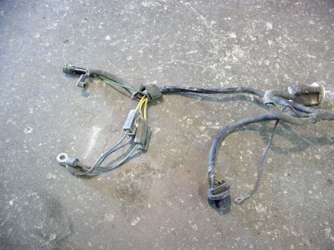 1988 Ford C-350 (Centurion Conversions) - A wiring harness, likely from an engine compartment, lies on a concrete floor. It features several connectors and bundles of wires.