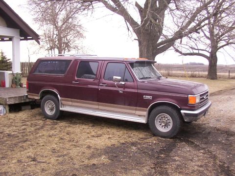 1988 Ford C-350 (Centurion Conversions) - This maroon Ford F-250 Centurion Conversion Van, likely from the late 1980s, is parked outside a rural building.