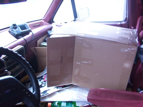 1988 Ford C-350 (Centurion Conversions) - Van interior is cluttered with boxes and personal items.