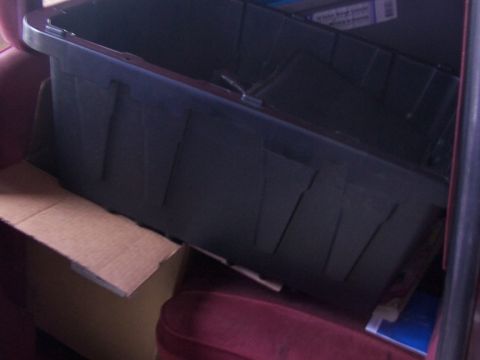 1988 Ford C-350 (Centurion Conversions) - Storage bins and boxes are placed on the maroon seats of a vehicle.