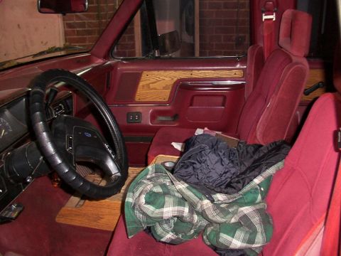 1988 Ford C-350 (Centurion Conversions) - Interior view of a 1988 Ford C-350, red velour upholstery and wood grain trim on the doors.