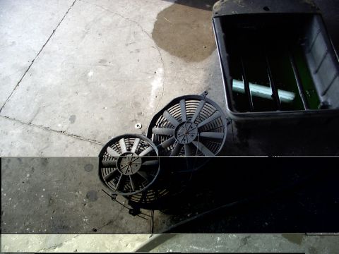 1988 Ford C-350 (Centurion Conversions) - Two cooling fans and a coolant reservoir sit on a concrete floor.