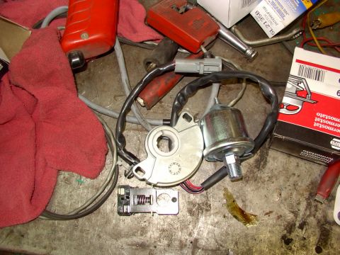 1988 Ford C-350 (Centurion Conversions) - Various automotive parts are laid out on a workbench, possibly for repair or replacement.