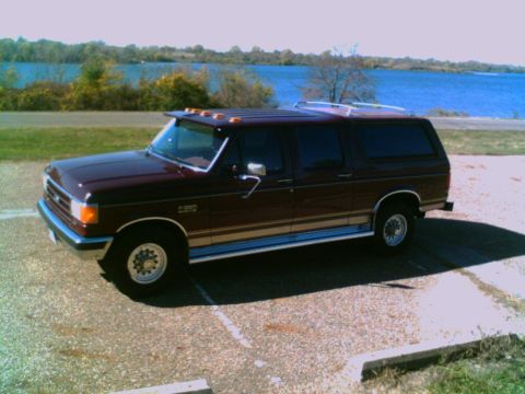 1988 Ford C-350 (Centurion Conversions) - Side view of a maroon Ford C-350 Centurion Conversion van parked near a body of water.