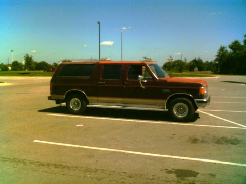 1988 Ford C-350 (Centurion Conversions) - This SUV, likely a 1987 model, is parked in a lot under a clear blue sky.