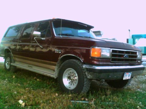 1988 Ford C-350 (Centurion Conversions) - Maroon Ford Bronco with tan side trim, parked on grass, shows a front 3/4 view.