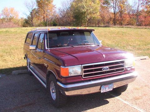 1988 Ford C-350 (Centurion Conversions) - Maroon Ford SUV with chrome trim and a sun visor parked outdoors.