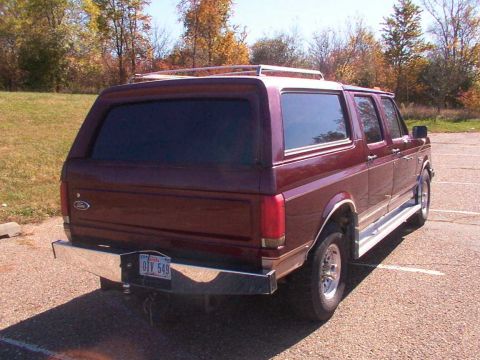 1988 Ford C-350 (Centurion Conversions) - Rear view of a maroon Ford SUV conversion with a chrome bumper and roof rack.