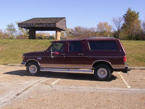 1988 Ford C-350 (Centurion Conversions) - Side view of a maroon Ford Bronco Centurion Conversion with tan trim, parked outdoors.