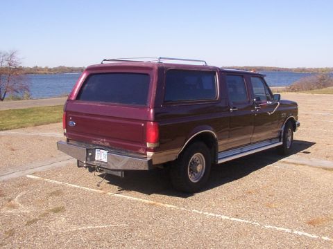 1988 Ford C-350 (Centurion Conversions) - Rear view of a maroon Ford Bronco with a camper shell and aftermarket bumper.
