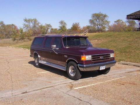 1988 Ford C-350 (Centurion Conversions) - This maroon SUV, likely a 1987 model based on its body style, is parked in an outdoor lot under a clear sky.