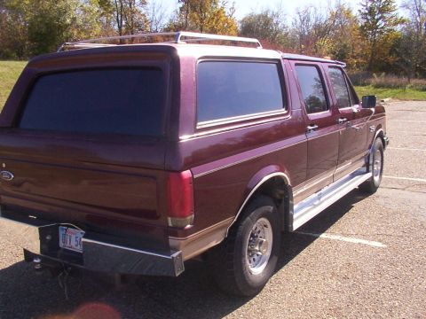 1988 Ford C-350 (Centurion Conversions) - This maroon SUV features a chrome roof rack and side trim, with a license plate visible on the rear bumper.