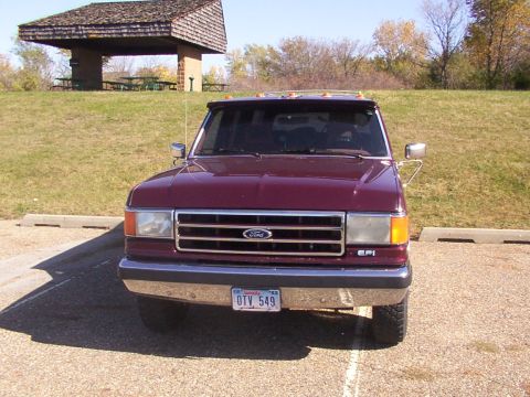 1988 Ford C-350 (Centurion Conversions) - Front view of a maroon 1988 Ford C-350 (Centurion Conversions) truck, a chrome grille and a license plate.