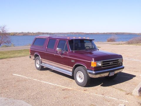 1988 Ford C-350 (Centurion Conversions) - Maroon Ford C-350 Centurion conversion van parked by a lake on a sunny day.