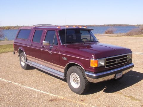 1988 Ford C-350 (Centurion Conversions) - This extended SUV, likely a Centurion conversion based on a Ford truck, is seen parked near a body of water on a sunny day.