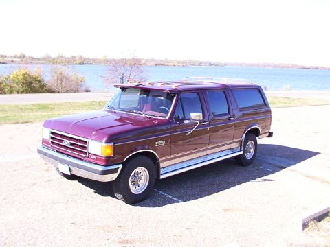 1988 Ford C-350 (Centurion Conversions) - This custom Ford SUV conversion is parked near a body of water on a clear day.