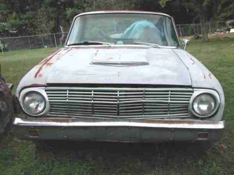 1973 Ford Ranchero - This vintage Ford Falcon Ranchero shows significant wear and tear, with rust visible on the hood and front bumper.