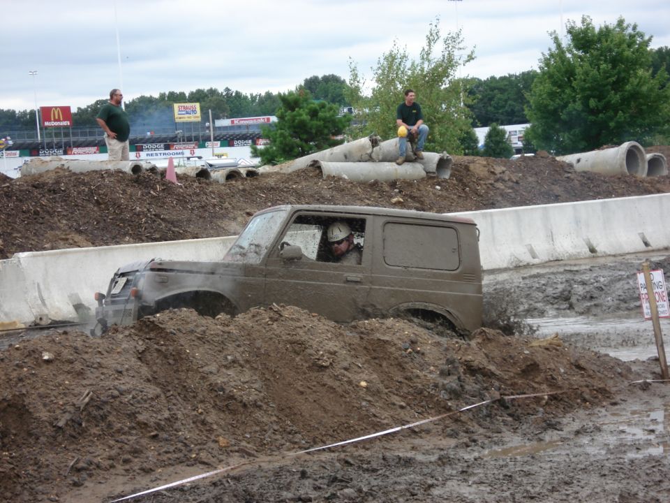 Muddy 1988 Suzuki Samurai navigating a mud bog