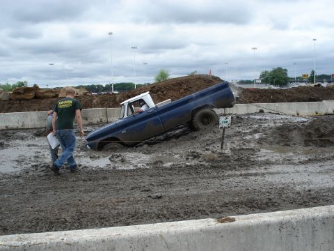 1988 Suzuki Samurai - Pickup truck stuck in mud during an event, with spectators watching.
