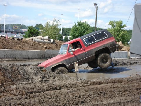 1988 Suzuki Samurai - This SUV is stuck in a mud bog, its front end submerged in thick mud.