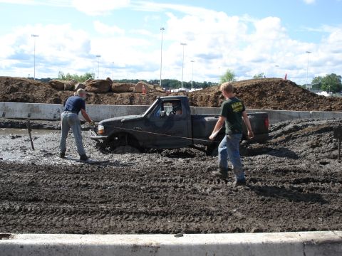 1988 Suzuki Samurai - Two men attempt to free a pickup truck that is deeply stuck in a mud pit.