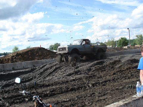 1988 Suzuki Samurai - Pickup truck modified for mud bogging, kicking up dirt and mud.