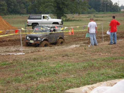 1988 Suzuki Samurai - A Suzuki Samurai navigates a muddy course, while another SUV waits behind.