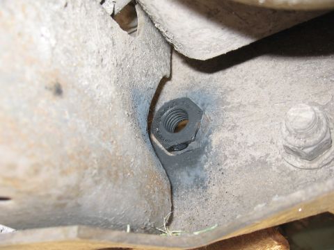 1974 Ford F-100 - A close-up view shows a nut and bolt assembly on a weathered metal component, likely from a vehicle's chassis.