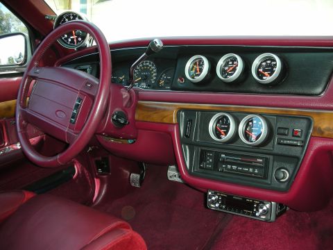 1992 Ford Crown Victoria - Interior view of a car with burgundy/maroon leather and carpet, showing the steering wheel, factory instrument cluster, and a custom dash-m…