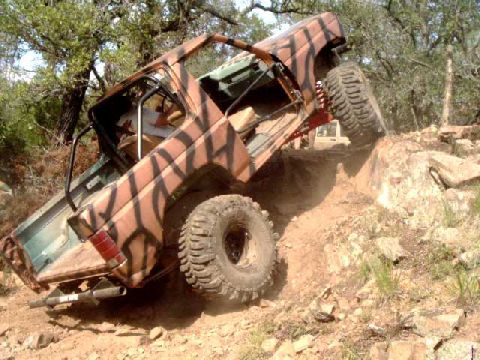 1984 Ford Bronco - This 1984 Ford Bronco navigates a challenging off-road course, its camouflage paint blending with the environment.