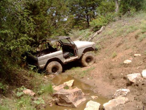 1984 Ford Bronco - This classic Ford Bronco navigates a challenging off-road course, splashing through mud and water.