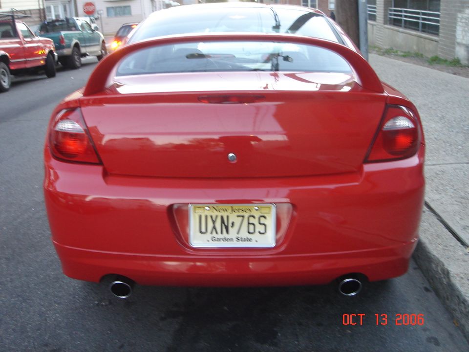 Red Dodge Neon SRT-4 rear view, parked on street. Other cars visible in background