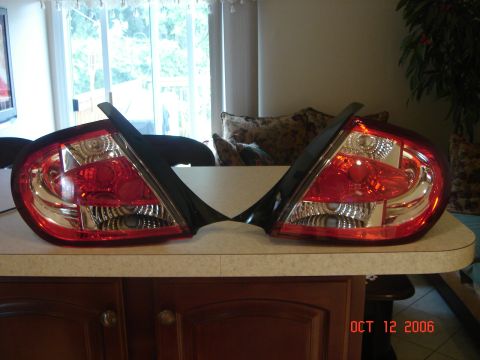2005 Dodge SRT-4 - A pair of red and clear tail lights are displayed on a counter, with a watermark indicating they were posted on October 12, 2006.