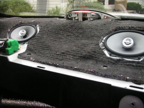 1999 Ford Taurus - The dashboard of a car is shown with the speakers removed, revealing the underlying insulation and wiring.