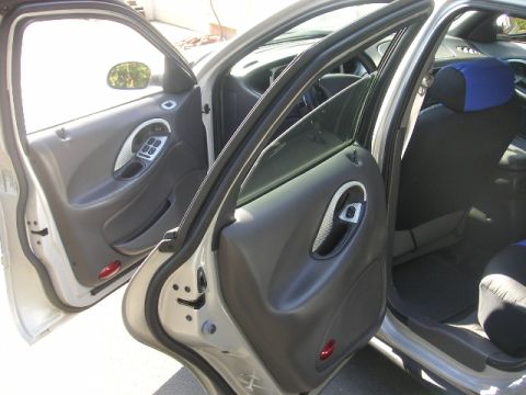 1999 Ford Taurus - View of the interior door panel and seats of a 1999 Ford Taurus, showing the driver's side door open.