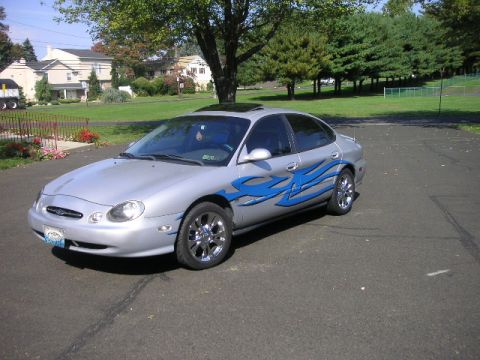 1999 Ford Taurus - Silver 1999 Ford Taurus parked on asphalt with a suburban background.