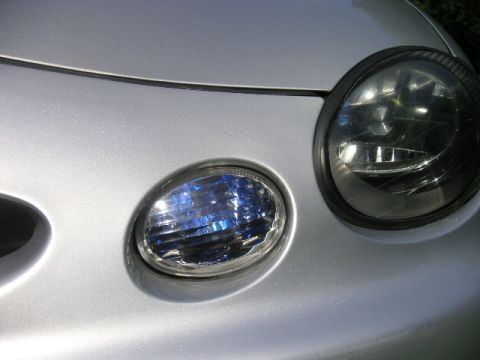 1999 Ford Taurus - Close-up of a silver car's front corner, showing the headlights and a fog light. The vehicle's year is not identifiable from this view.