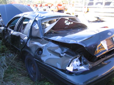 1991 Ford LTD Crown Victoria - This sedan has sustained significant rear-end damage, with the trunk and hood open.