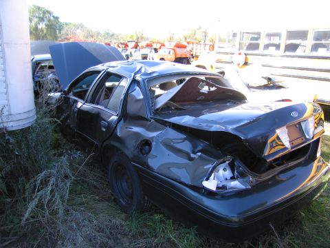 1991 Ford LTD Crown Victoria - This heavily damaged sedan sits in a junkyard, its rear end crushed and roof caved in.