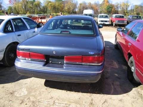 1991 Ford LTD Crown Victoria - The rear of a blue 1991 Ford Crown Victoria LTD is visible, parked outdoors with other vehicles.