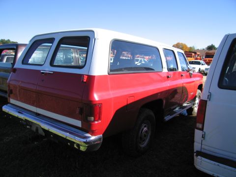 1991 Ford LTD Crown Victoria - A red and white SUV is seen from the rear, parked in an outdoor lot with other vehicles.