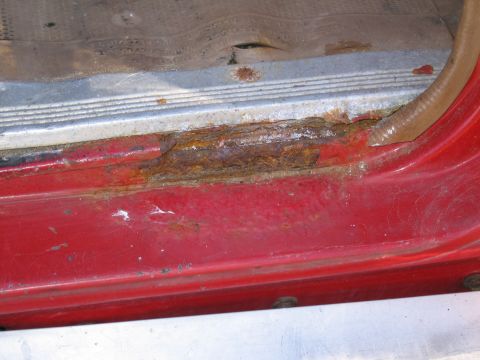 1991 Ford LTD Crown Victoria - Rust damage is visible on the door sill and lower door frame of a vehicle.