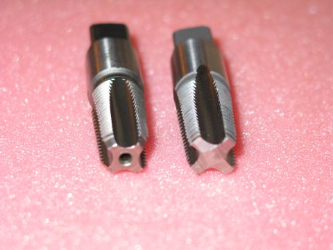 1981 Ford Bronco - Two metal taps are shown up close, with their threaded cutting edges visible against a pink background.