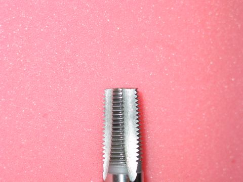 1981 Ford Bronco - A tap, a tool used for creating screw threads, is shown in detail against a pink background.